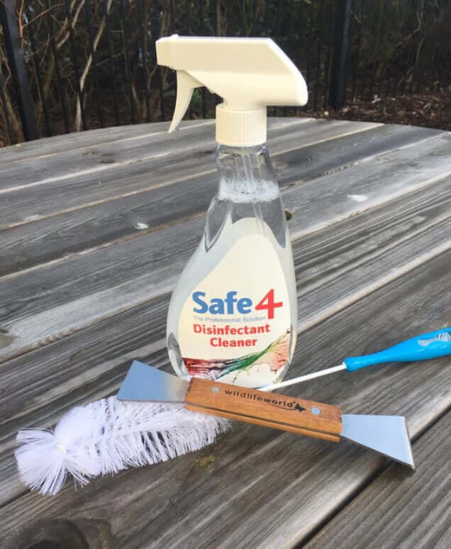 Bottle of Safe4 Disinfectant Cleaner with a brush and scraper.