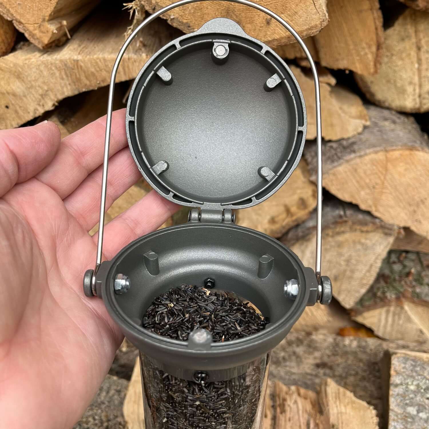 Pewter feeder for niger seed with flick top on a hinge so can be opened easily.