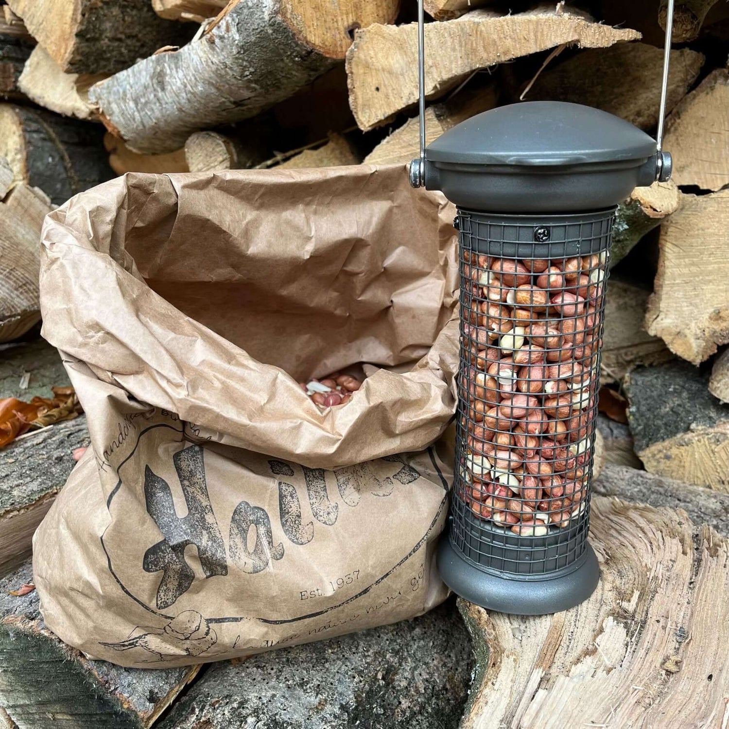 A bag of Haith's Premium peanuts and a metal flick and click peanut feeder 
