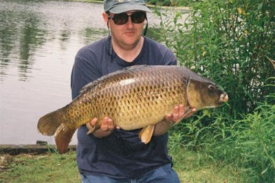 Image of fisherman holding a carp