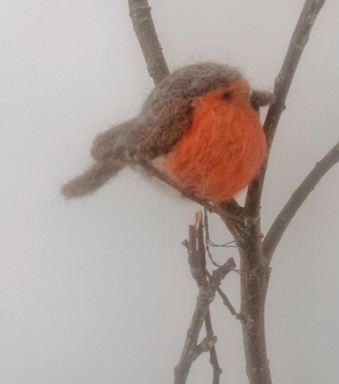 needle felted robin sat on a branch