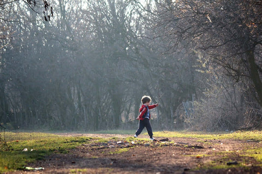 Child playing outside in a woodland. 