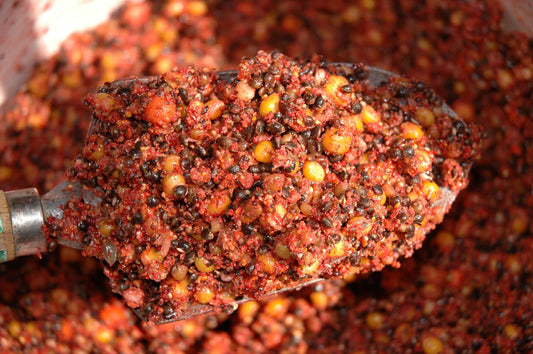 A spoonful of red, seed fishing bait. 