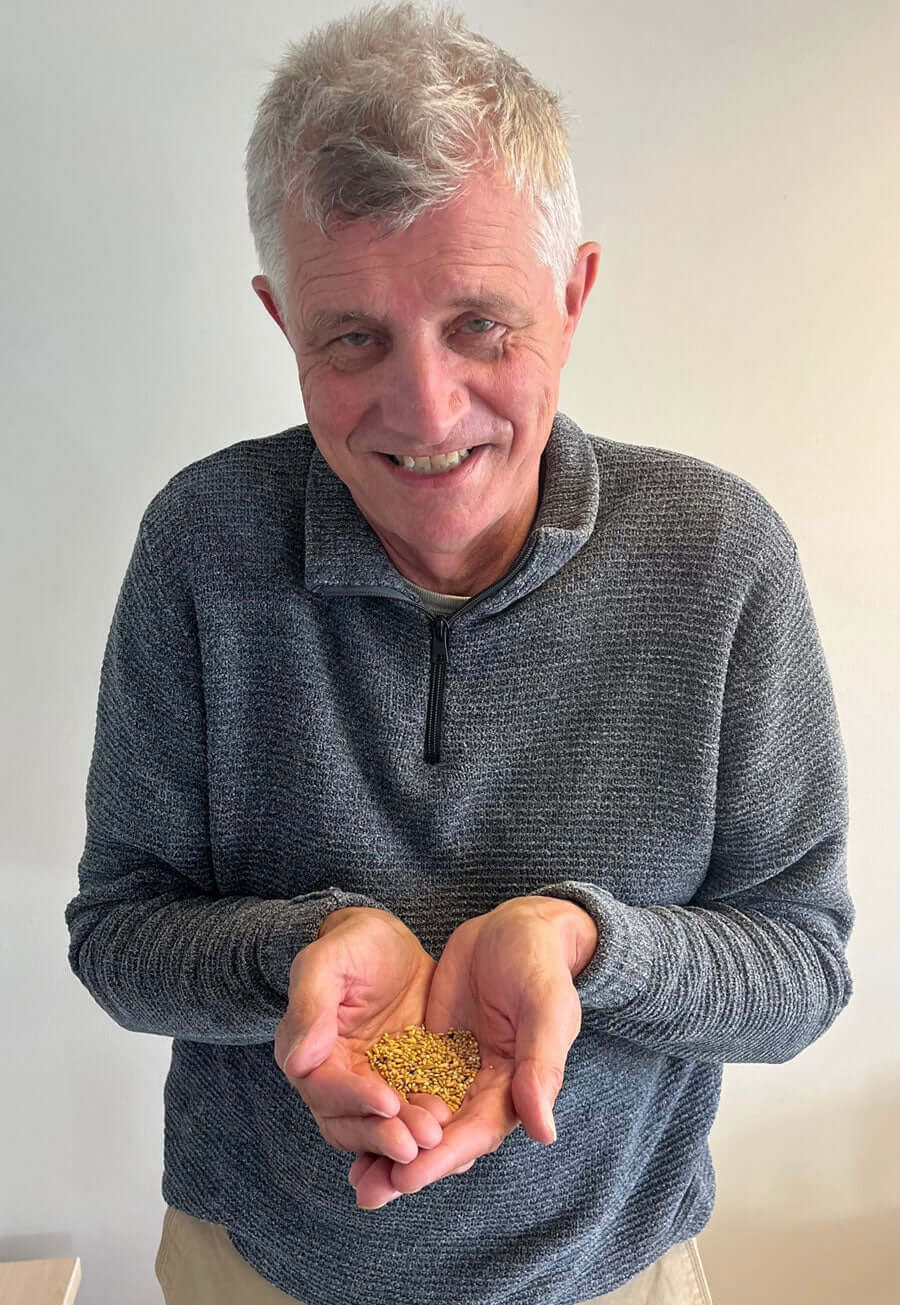 man holding a small handful of seed