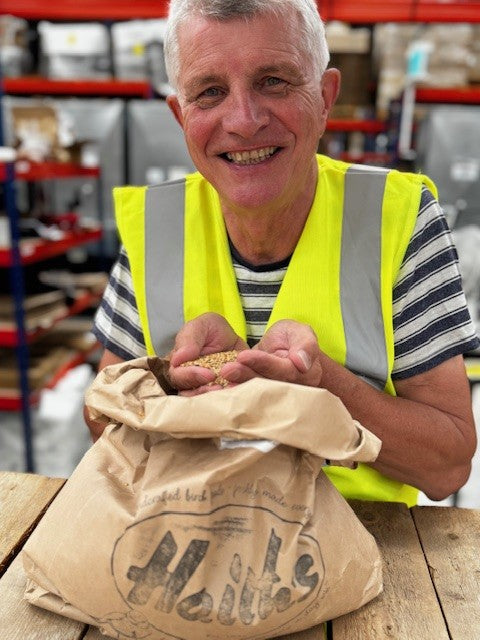 Man in a warehouse holding a bag of seeds