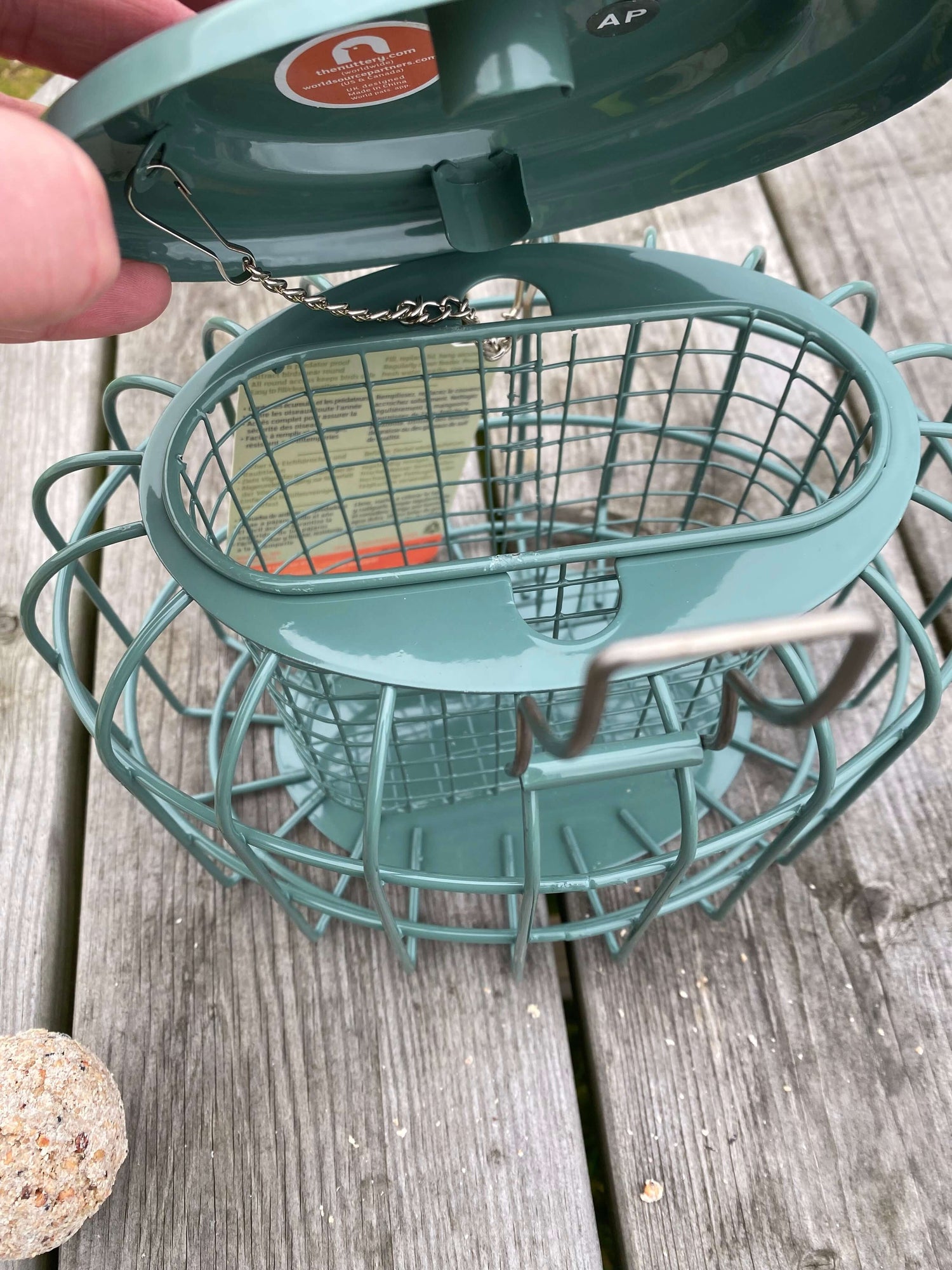 Caged suet feeder which holds suet feasts and small fat balls . Has special designed handle which locks lid