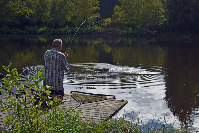 man fishing on a lakeside
