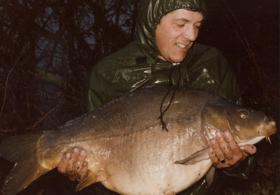 Ken Townley holding a large carp night fishing