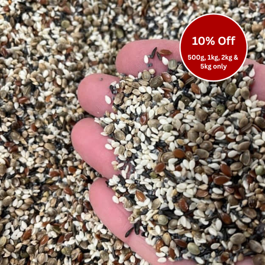 Hand holding a mixture of seeds with a promotional label for discounts on larger quantities.