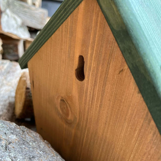 Wooden nest box with hole in the back, to hang securely to a fence or a tree.