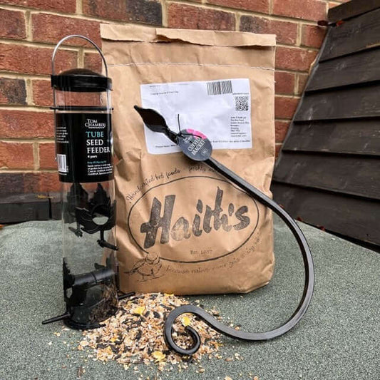 Bird feeding pack made up of a 4 port seed feeder, curved bracket which when fitted to the wall will hold the feeder and a bag of bird seed